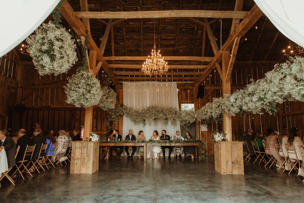 guests sitting down to dinner at Prim Peony Event Co. decorated with babies breath clouds.
