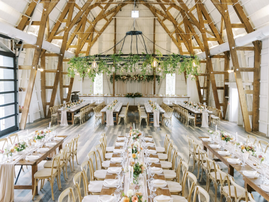 white barn with wood beams decorated for a wedding at Crescent Hill Acres.